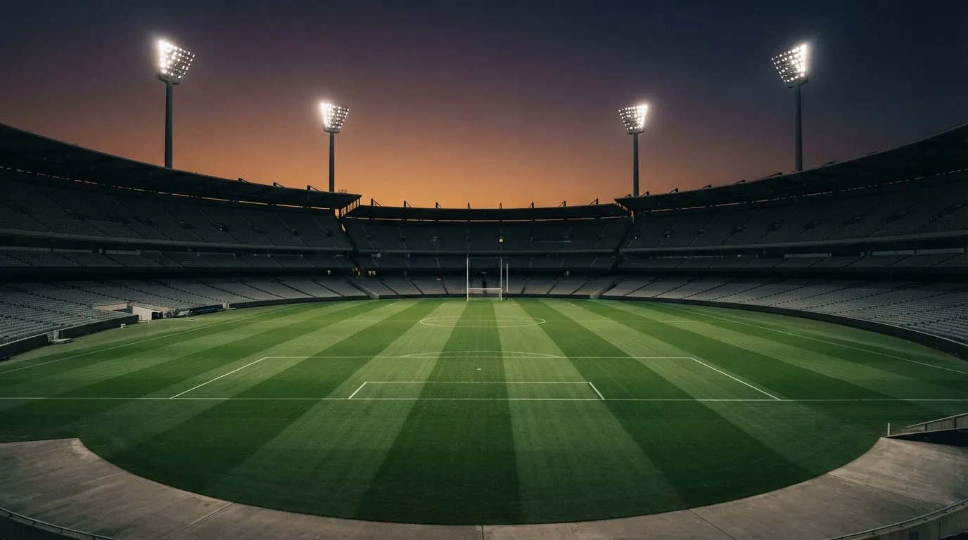 Een leeg voetbalstadion met lichtmasten bij schemering