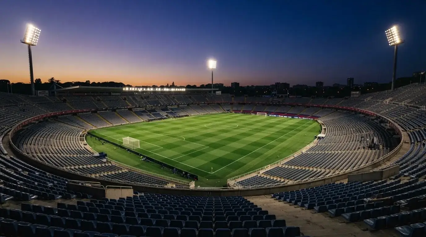 Een leeg voetbalstadion met lichtmasten bij schemering